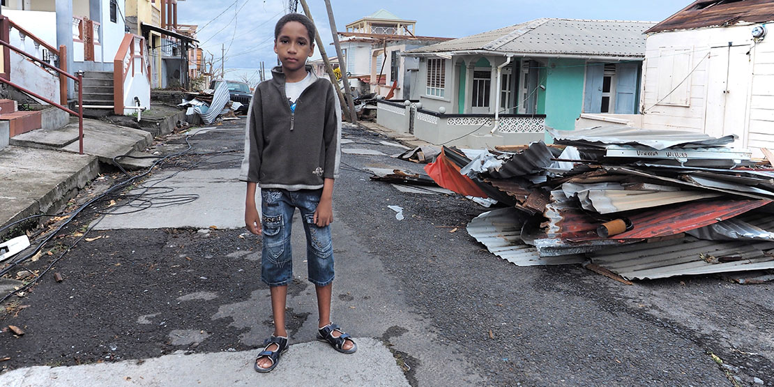 Young boy on a street in Puerto Rico damaged by hurricane Maria.