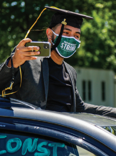 Students taking a picture out of car sunroof during Car-mencement