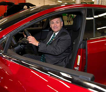 President John Nader sitting in a Tesla vehicle