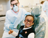 A child in a dental chair receiving a cleaning