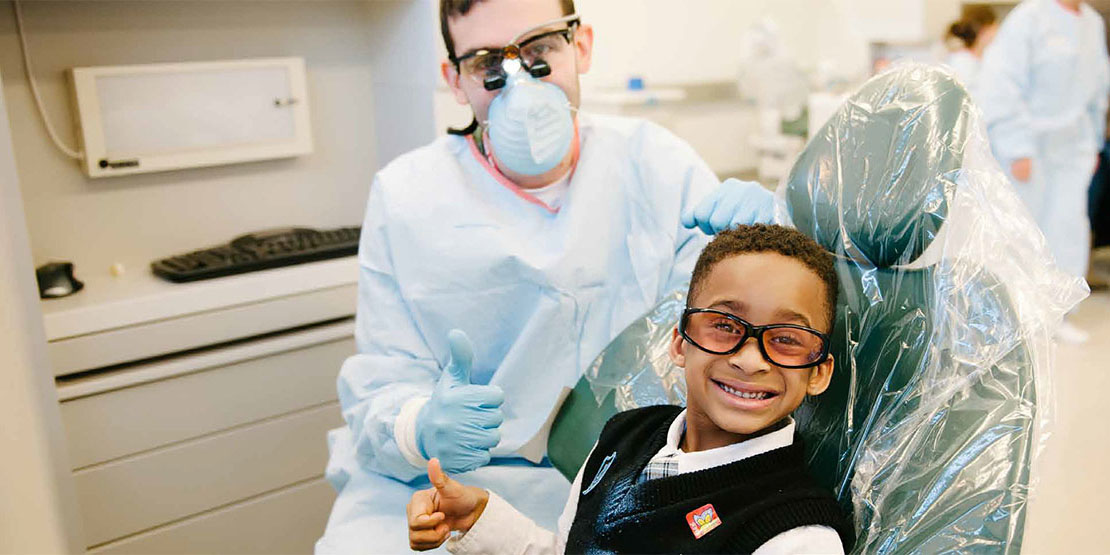 A child in a dental chair receiving a cleaning