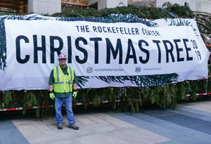 Erik Pauze standing in front of the Rockefeller Center Christmas Tree