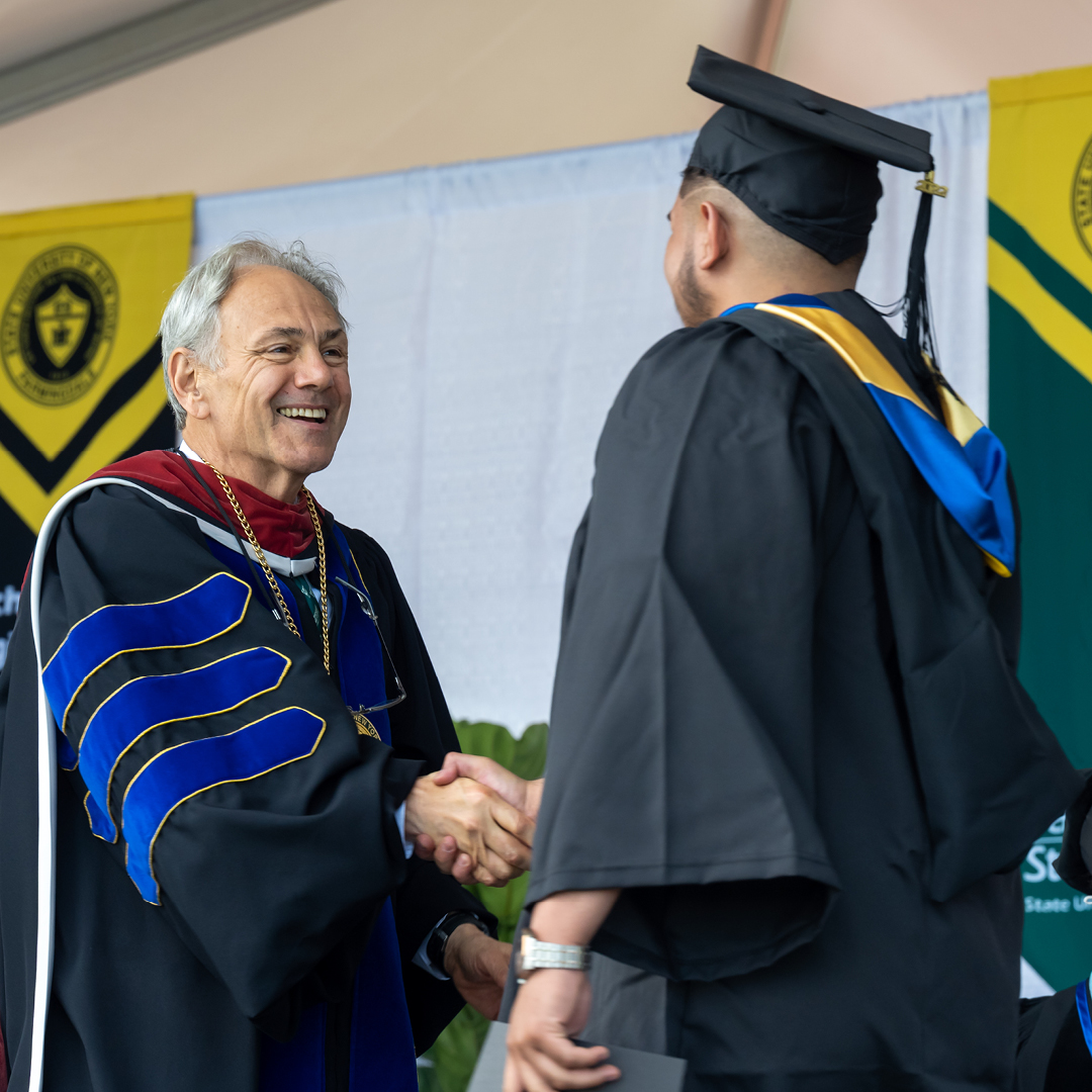 President Nader shaking the hands of a graduating student