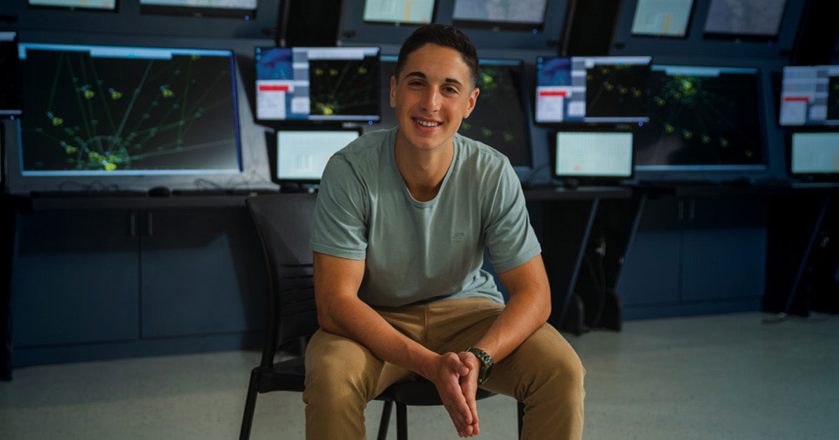 Ethan Bassis, FSC student and pilot, smiling in front of an airplane