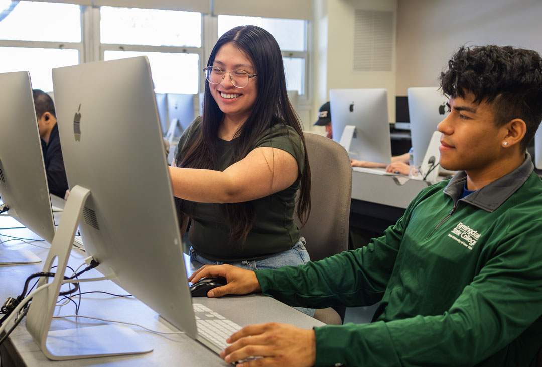Two students working together in a computer lab