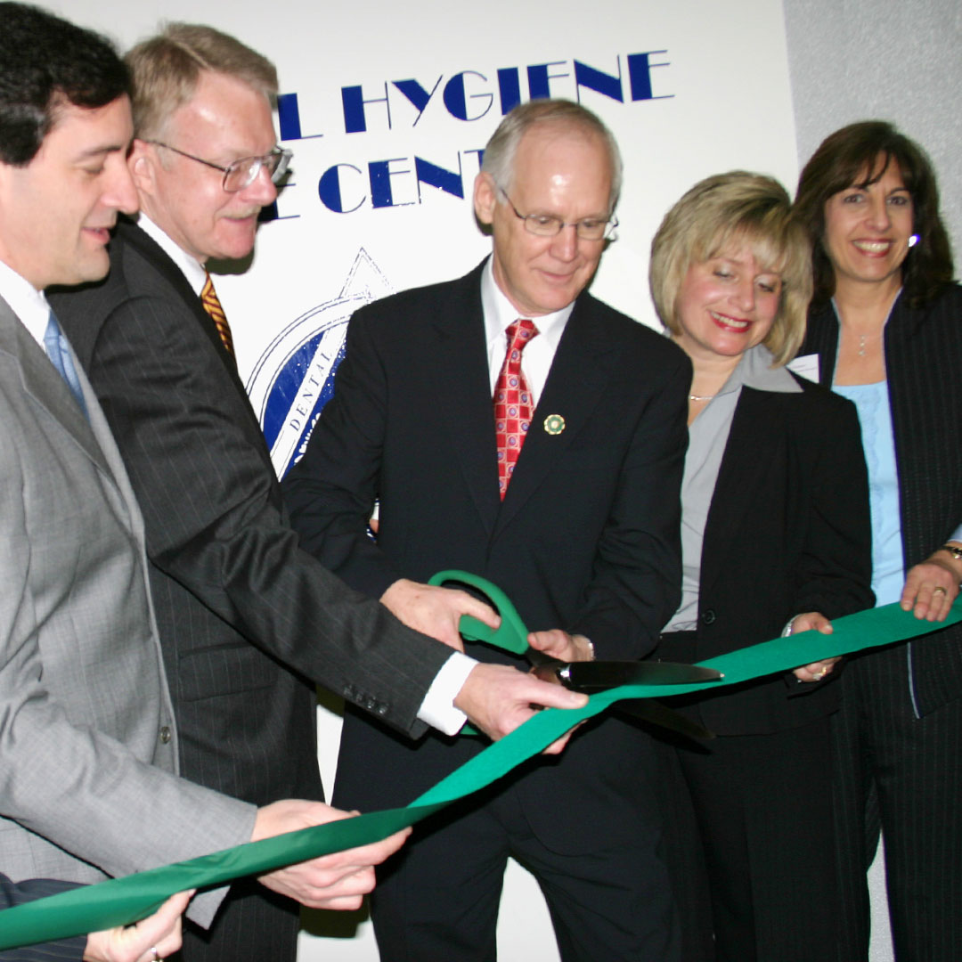 Dr. Laura Joseph cutting a ribbon for the dental hygiene center