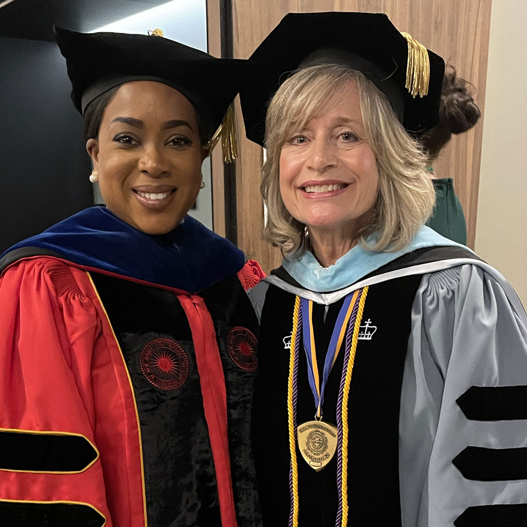 Dr. Laura Joseph in regalia with office of community engagement staff member, Yetunde.