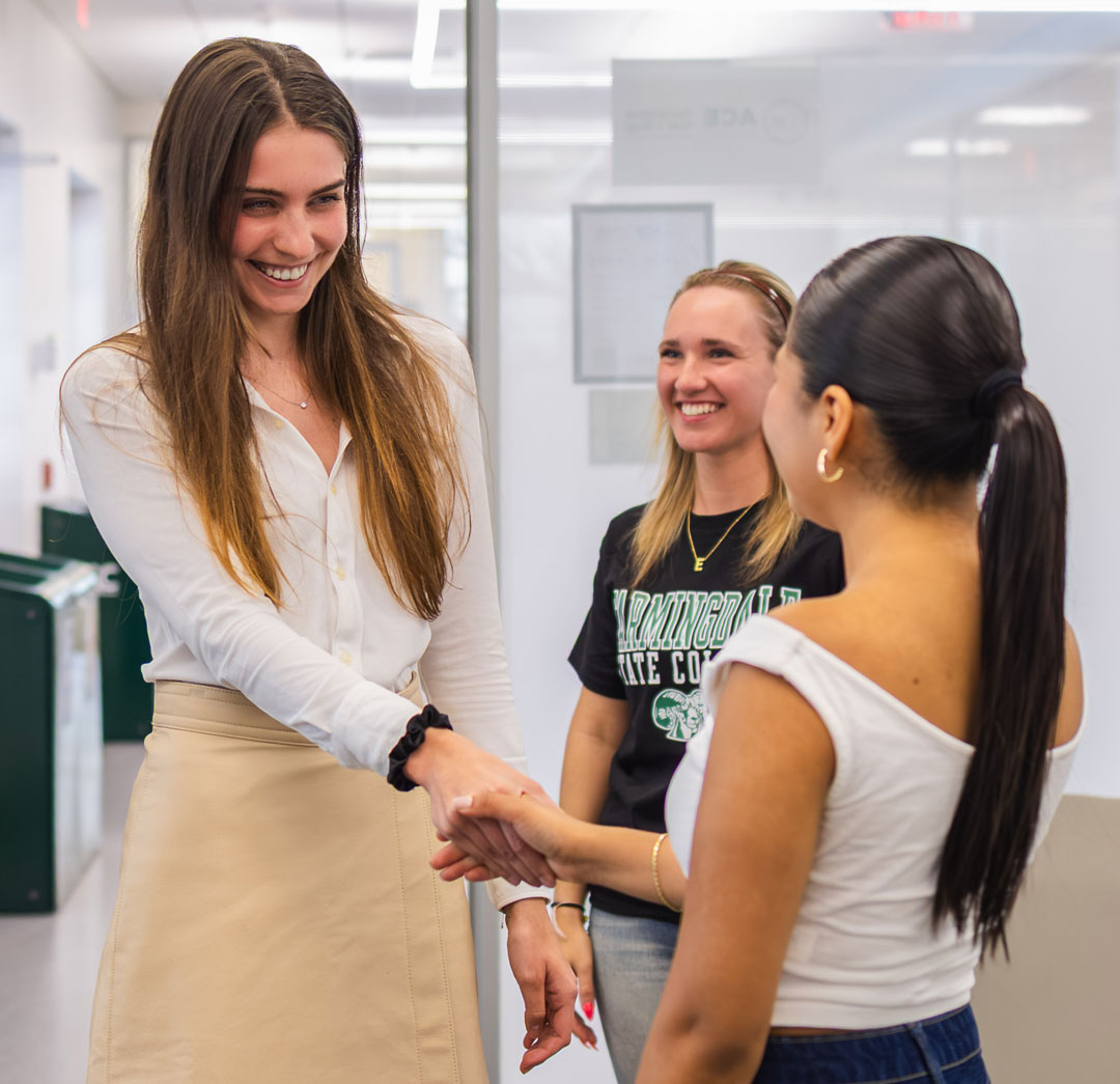 Photo of an ACE staff member shaking hands with a student
