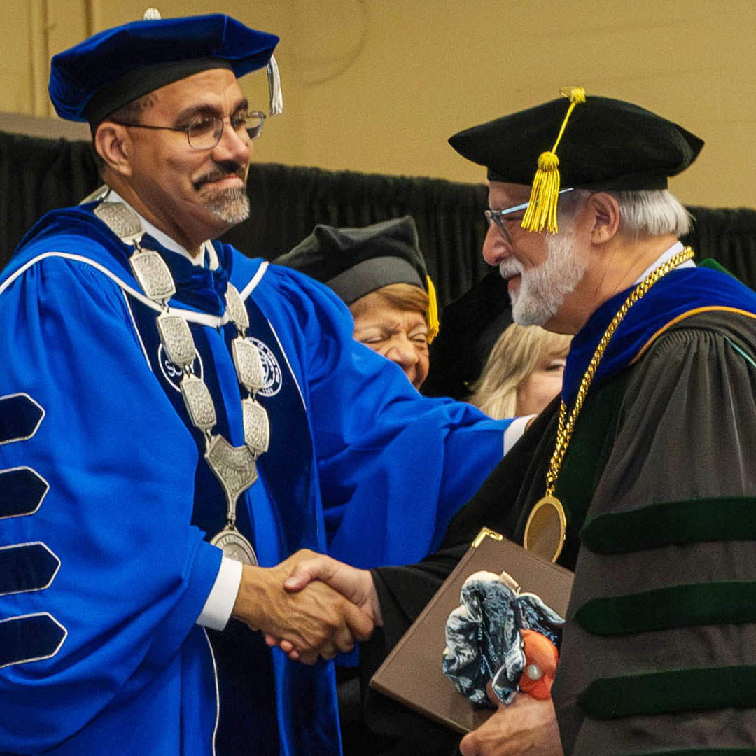 Dr. Prezant in regalia shaking hands with SUNY Chancellor King at Dr. Prezant's Inauguration