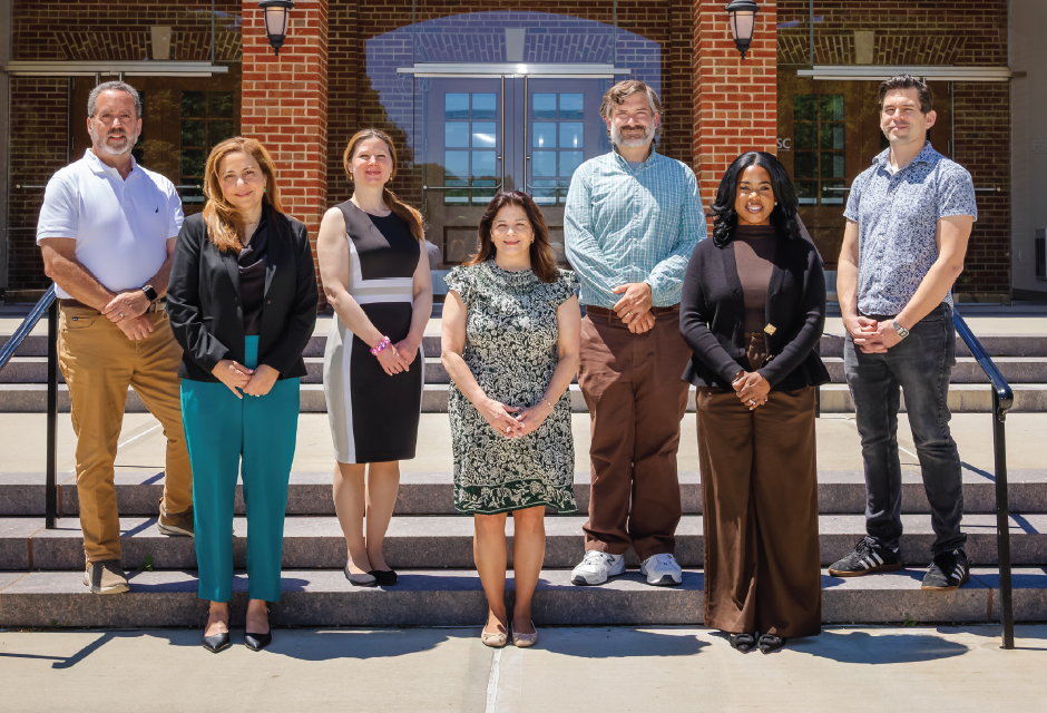 Group of faculty members standing on the steps of Knapp Hall